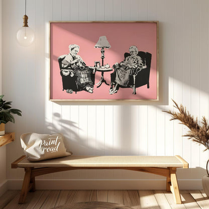 This iconic Banksy print, titled “Grannies,” features two elderly women seated in armchairs, dilige… for entryway
