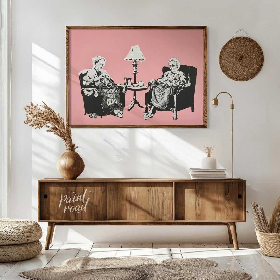 This iconic Banksy print, titled “Grannies,” features two elderly women seated in armchairs, dilige… for living room