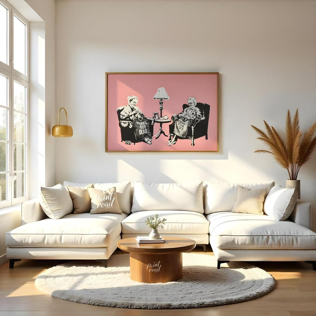 This iconic Banksy print, titled “Grannies,” features two elderly women seated in armchairs, dilige… for living room