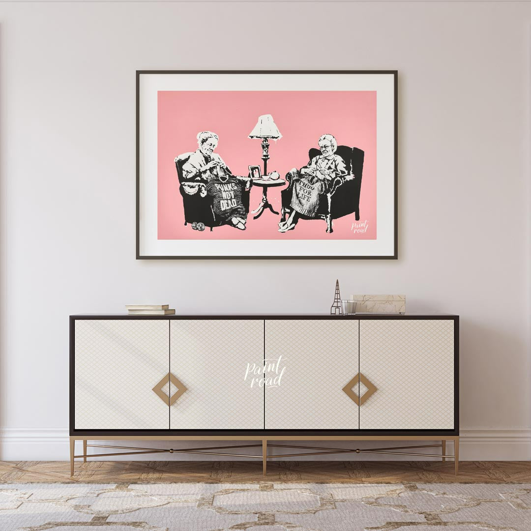 This iconic Banksy print, titled “Grannies,” features two elderly women seated in armchairs, dilige… for living room