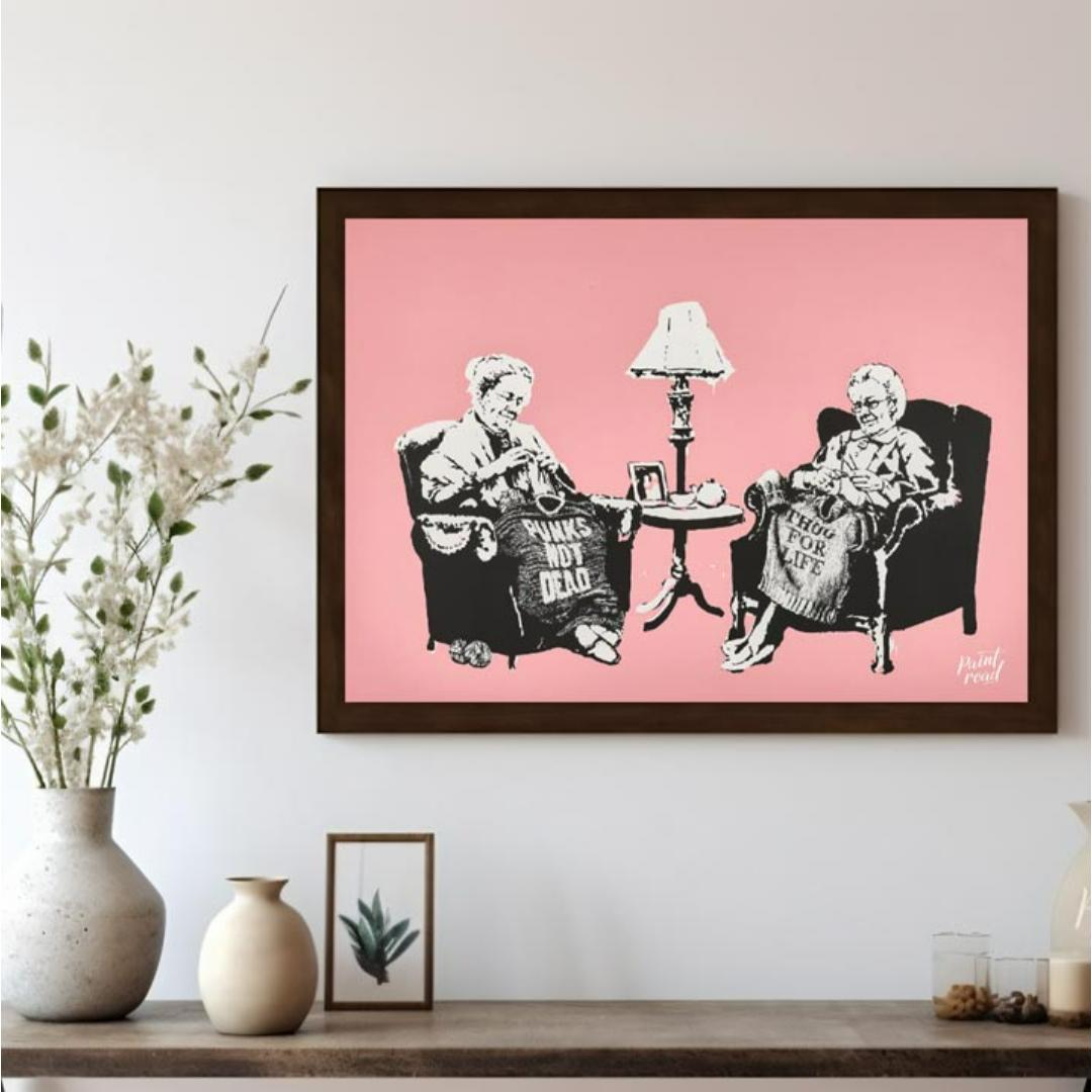 This iconic Banksy print, titled “Grannies,” features two elderly women seated in armchairs, dilige… for living room