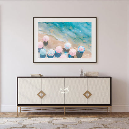 This aerial photograph captures a serene beach scene, showcasing a collection of pastel-colored par… for living room