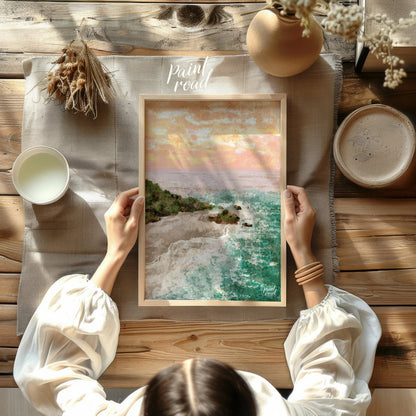 This artwork captures a serene coastal landscape at sunset. The sky is awash with soft hues of oran… for other