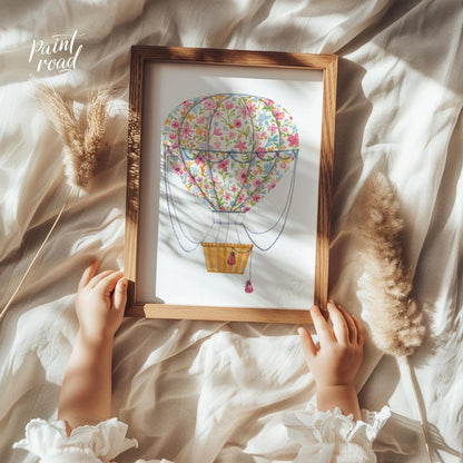This vibrant watercolor illustration depicts a whimsical hot air balloon wrapped in a bouquet of ri… for nursery