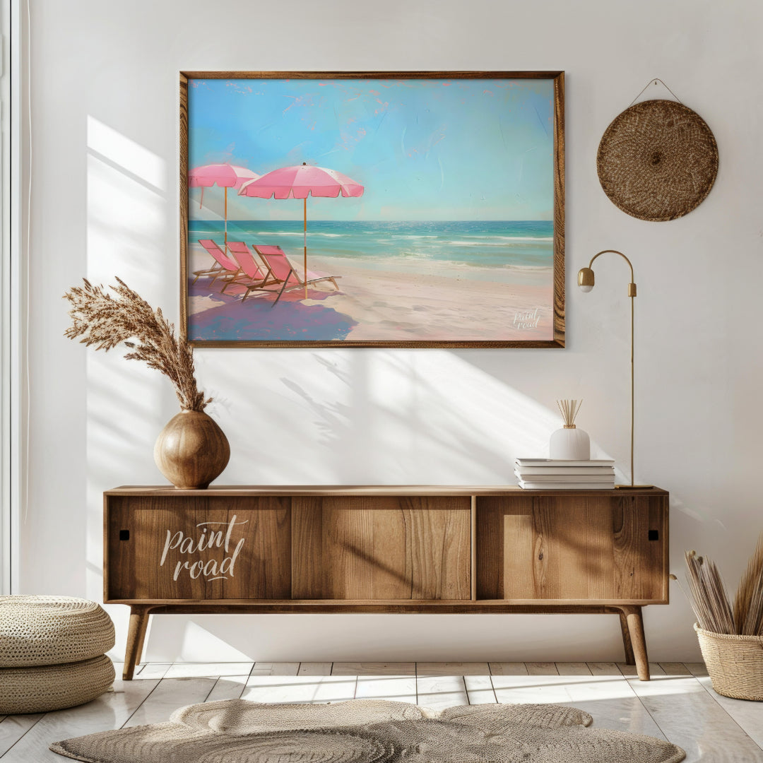 This artwork captures a tranquil beach scene with two pink parasols and matching lounge chairs set … for living room