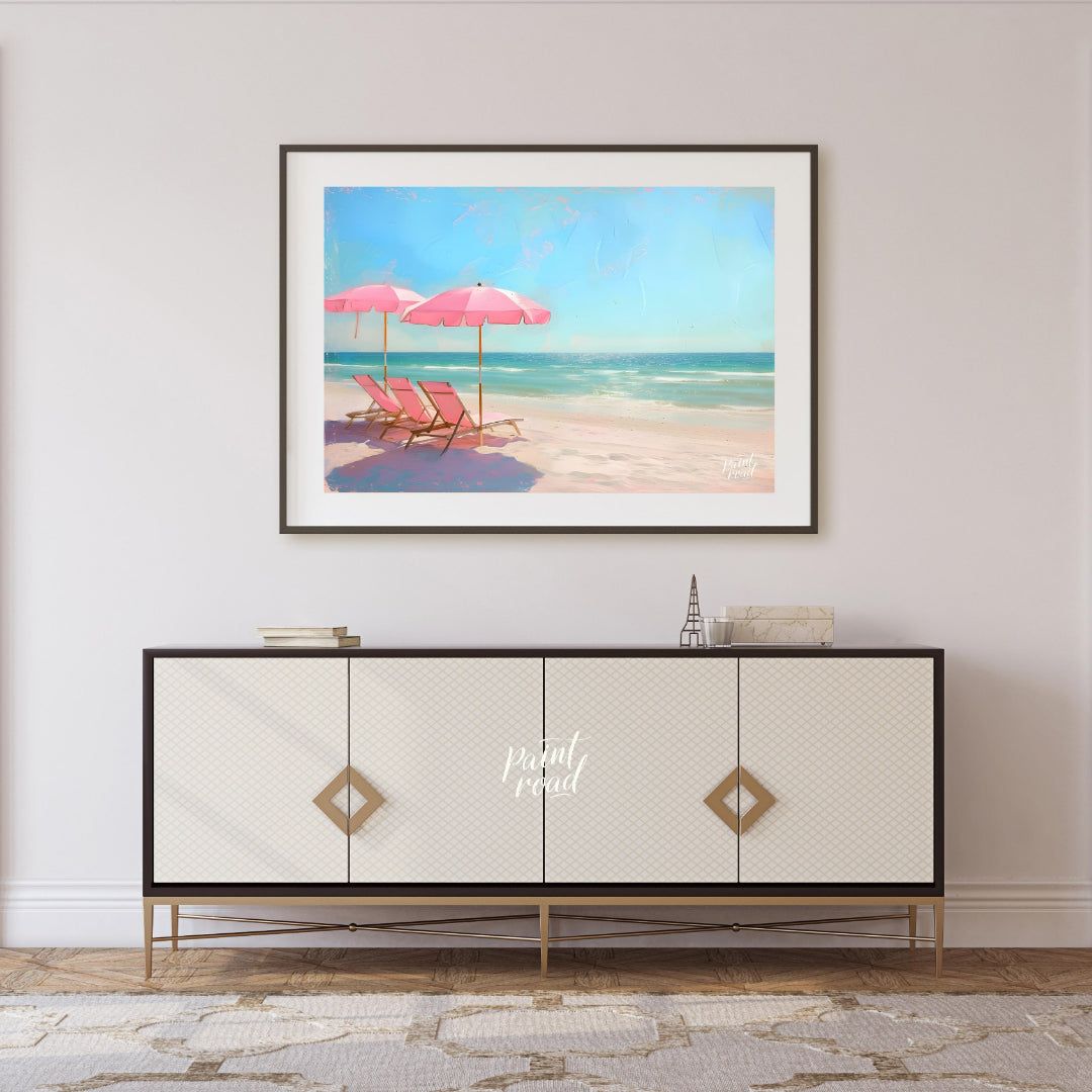 This artwork captures a tranquil beach scene with two pink parasols and matching lounge chairs set … for living room