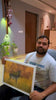 Male customer from Bangalore in his thirties wearing white shirt talking about the superior and premium build quality and canvas painting ordered from paintroad.com 