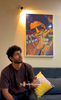 Young Generation Male customer with curly hair from Bangalore in his twenties wearing white shirt talking about the unique and modern designs and GenZ vibes of canvas painting ordered from paintroad.com 