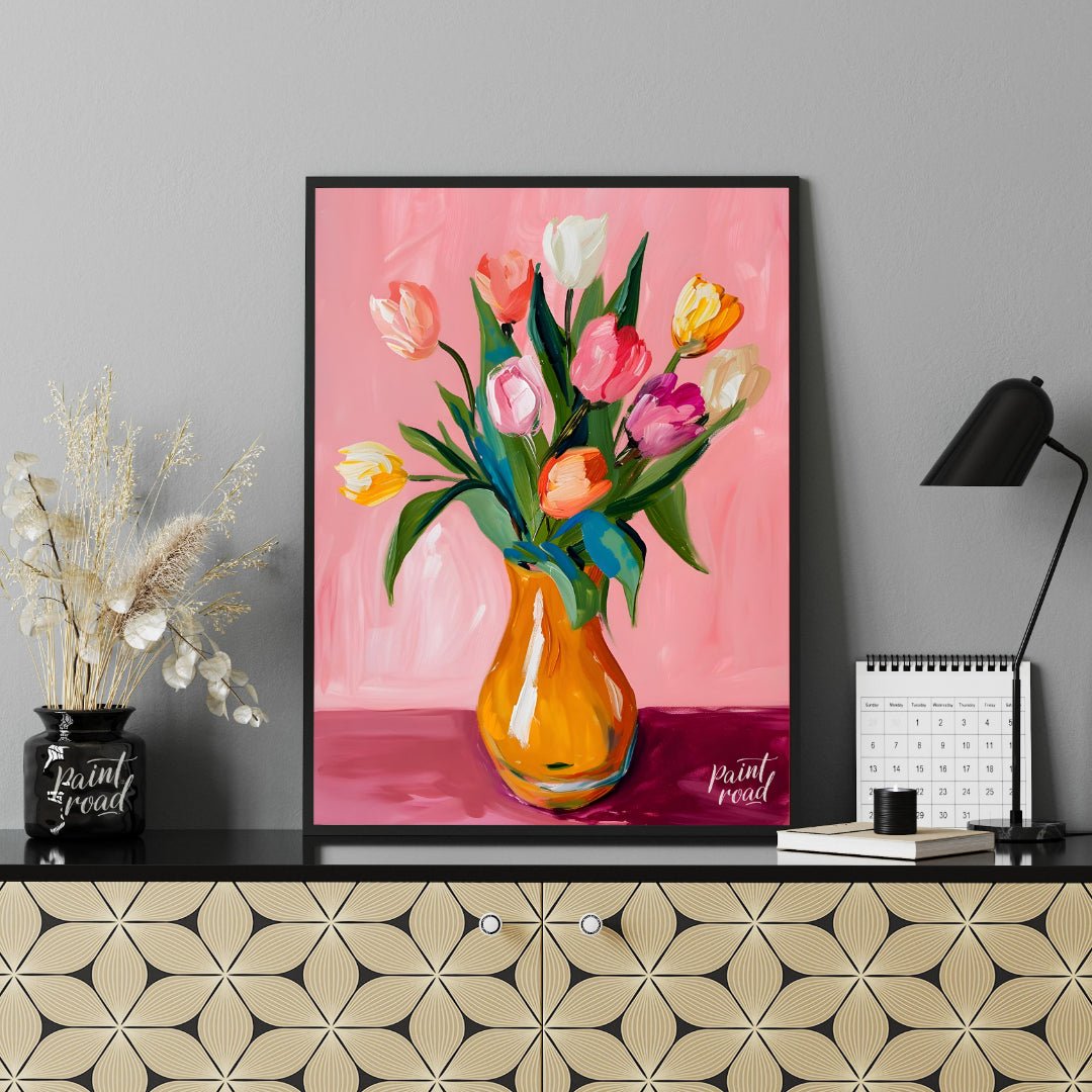 This charming artwork features a bouquet of tulips in a vibrant orange vase, set against a soft pin… for office